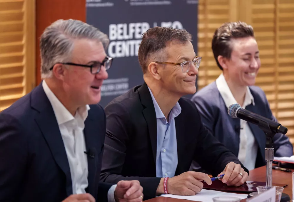 Eric Rosenbach, Dr. Colin Kahl, and Bethany Russell laughing smiling while sitting at the panel table.