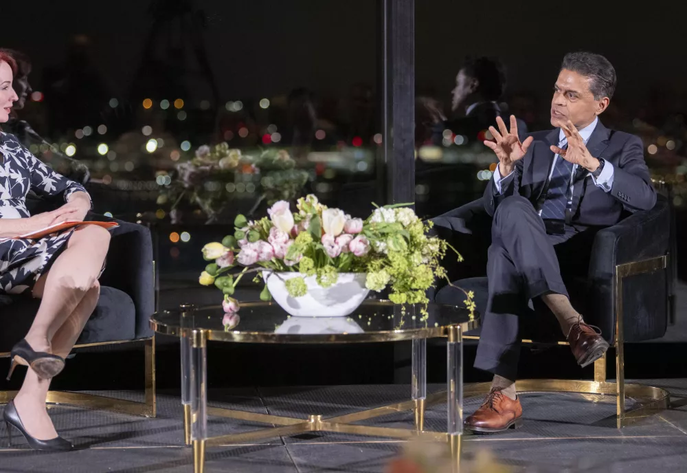 Meghan L O'Sullivan and Fareed Zakaria on stage at the State Room with the lights of Boston in the background.