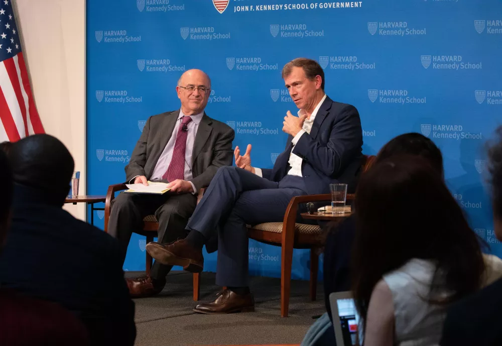 Henry Lee with Nat Keohane against blue Harvard Kennedy School background