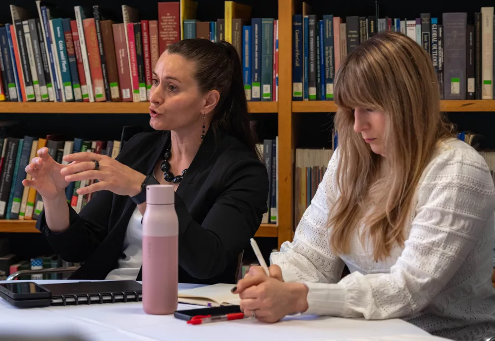 Cait Conley speaks in the Belfer Library seated at the table next to Lauren Zabierek.