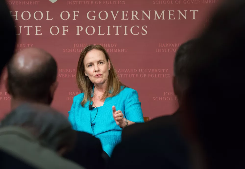 Flournoy speaks onstage in the JFK Jr. forum. Silhouettes of the audience in the foreground.