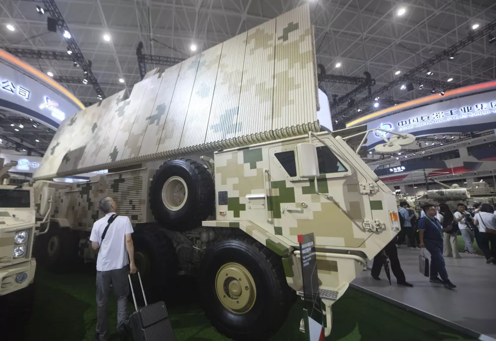 A large military camouflage truck in a in a convention center.