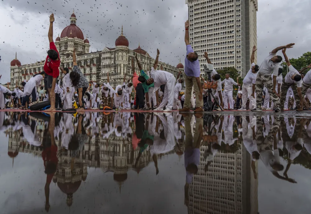 People perform Yoga to mark International Day of Yoga in front of Taj Mahal Palace hotel in Mumbai, India, Tuesday, June 21, 2022. Yoga enthusiasts across the world Tuesday took part in mass yoga events to mark Yoga Day. (AP Photo/Rafiq Maqbool)
