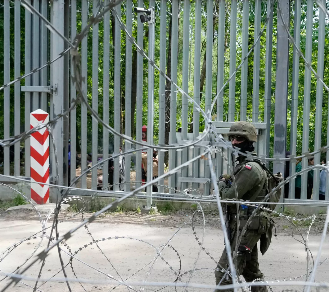 A soldier standing guard behind a fence
