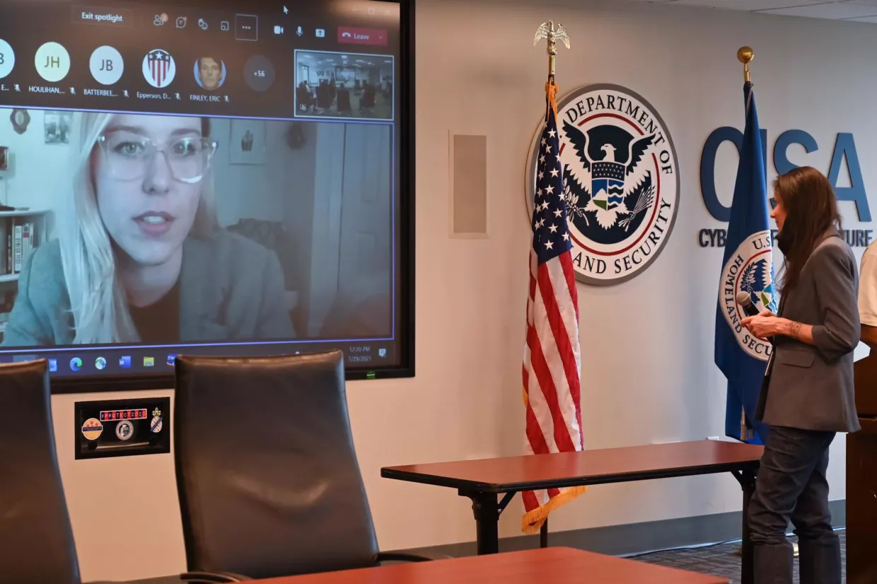 Stefani Jones on a video conference monitor speaking to someone in a room at CISA offices.