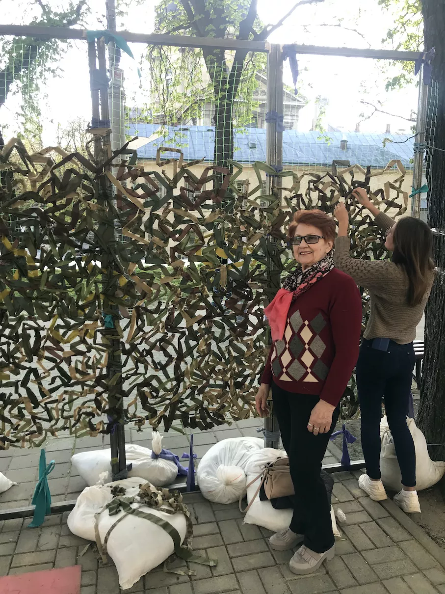 Mariana’s mother Iryna as a volunteer, next to the camouflage net.