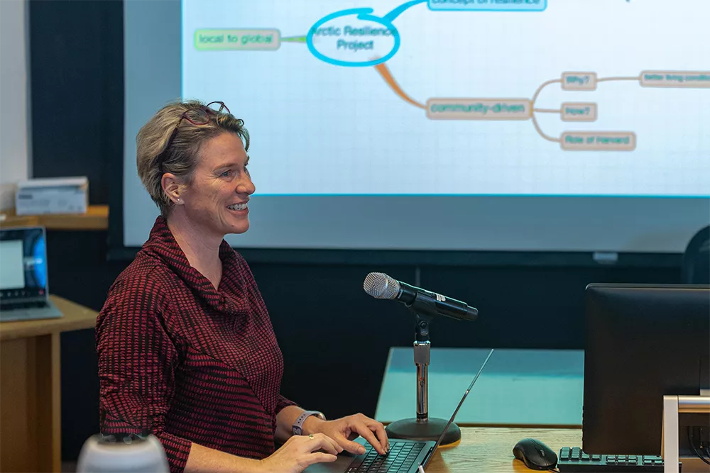 Jennifer Spence stands at a podium with a laptop
