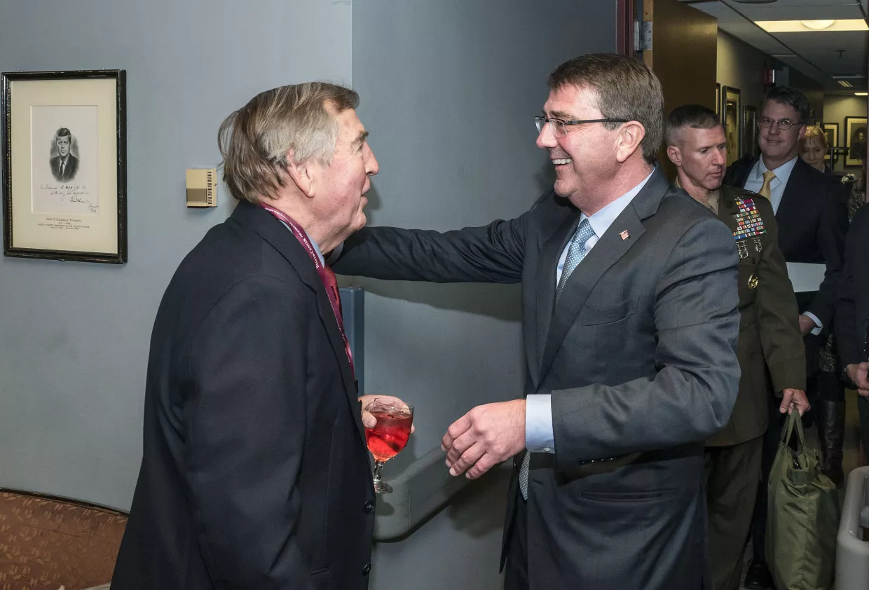 Ash Carter with his arms raised about to hug Graham Allison who is greeting him.