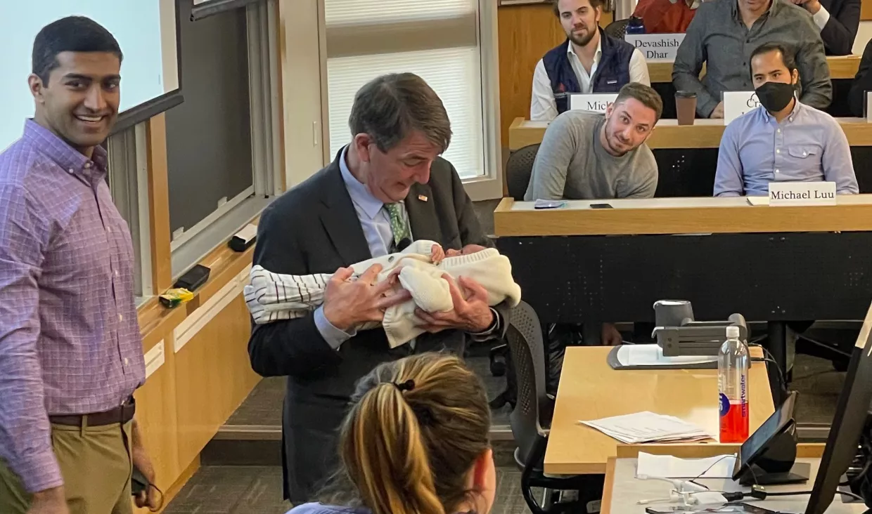Ash Carter holding Kiran Iyer, Akhil Iyer's son, during a class session.
