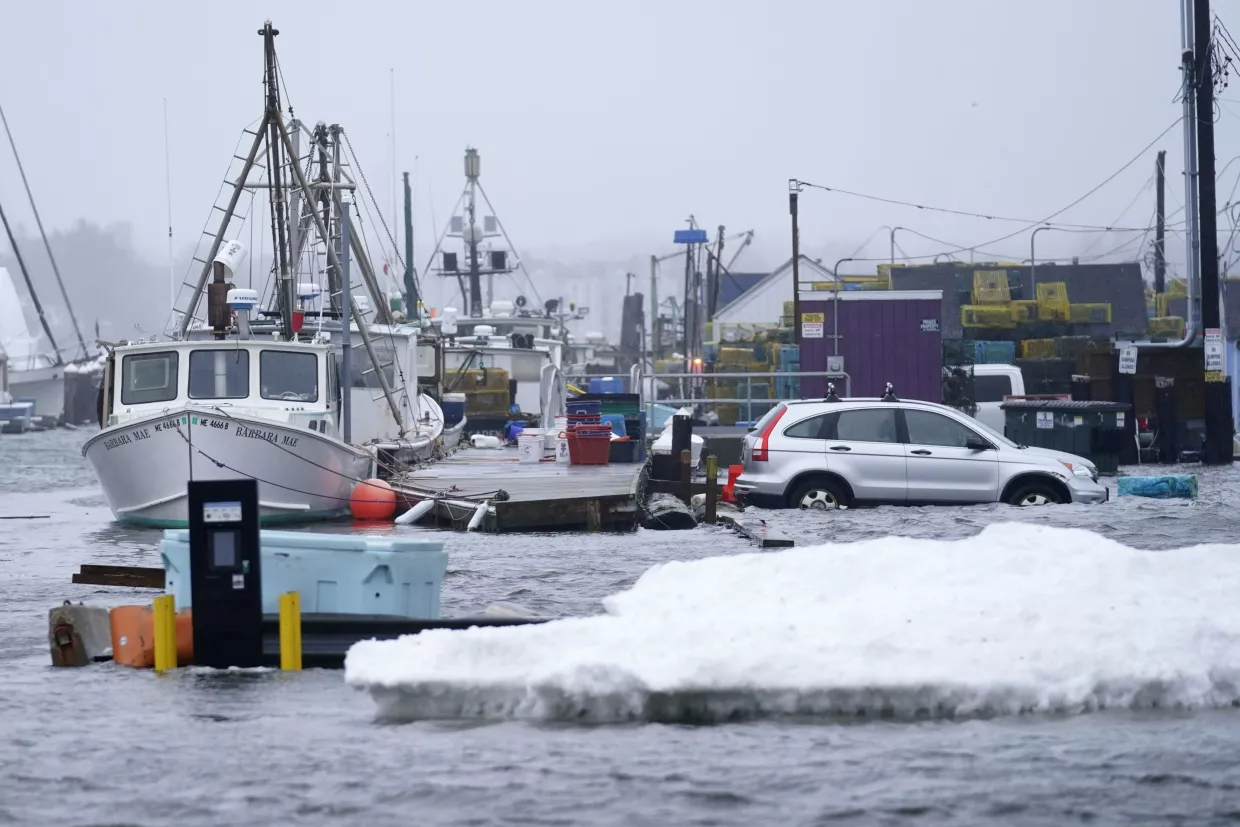A car sits in a flooded parking lot at Widgery Wharf