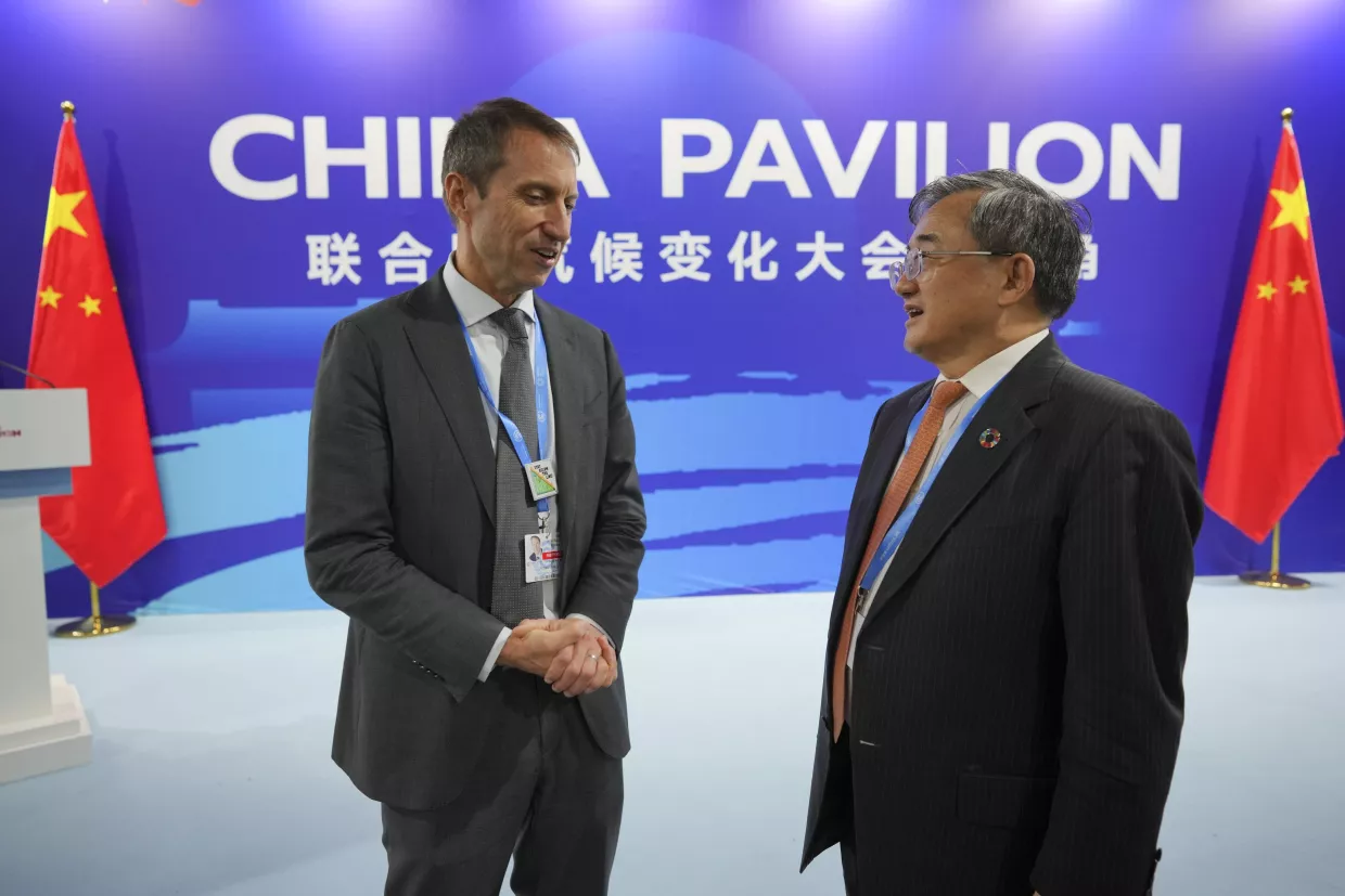 Liu Zhenmin, China's climate envoy, right, and Rick Duke, deputy climate envoy for the United States, talk at the China Pavilion during the COP29 U.N. Climate Summit, Wednesday, Nov. 20, 2024, in Baku, Azerbaijan. 