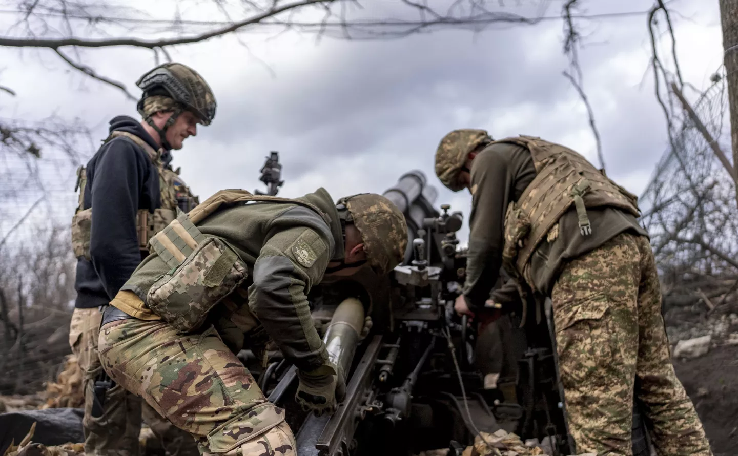 Ukrainian servicemen of Khartia brigade loading shell into M101 Howitzer before firing towards Russian positions in Kharkiv region, Ukraine, Wednesday, March 12, 2025. (AP Photo/Alex Babenko)
