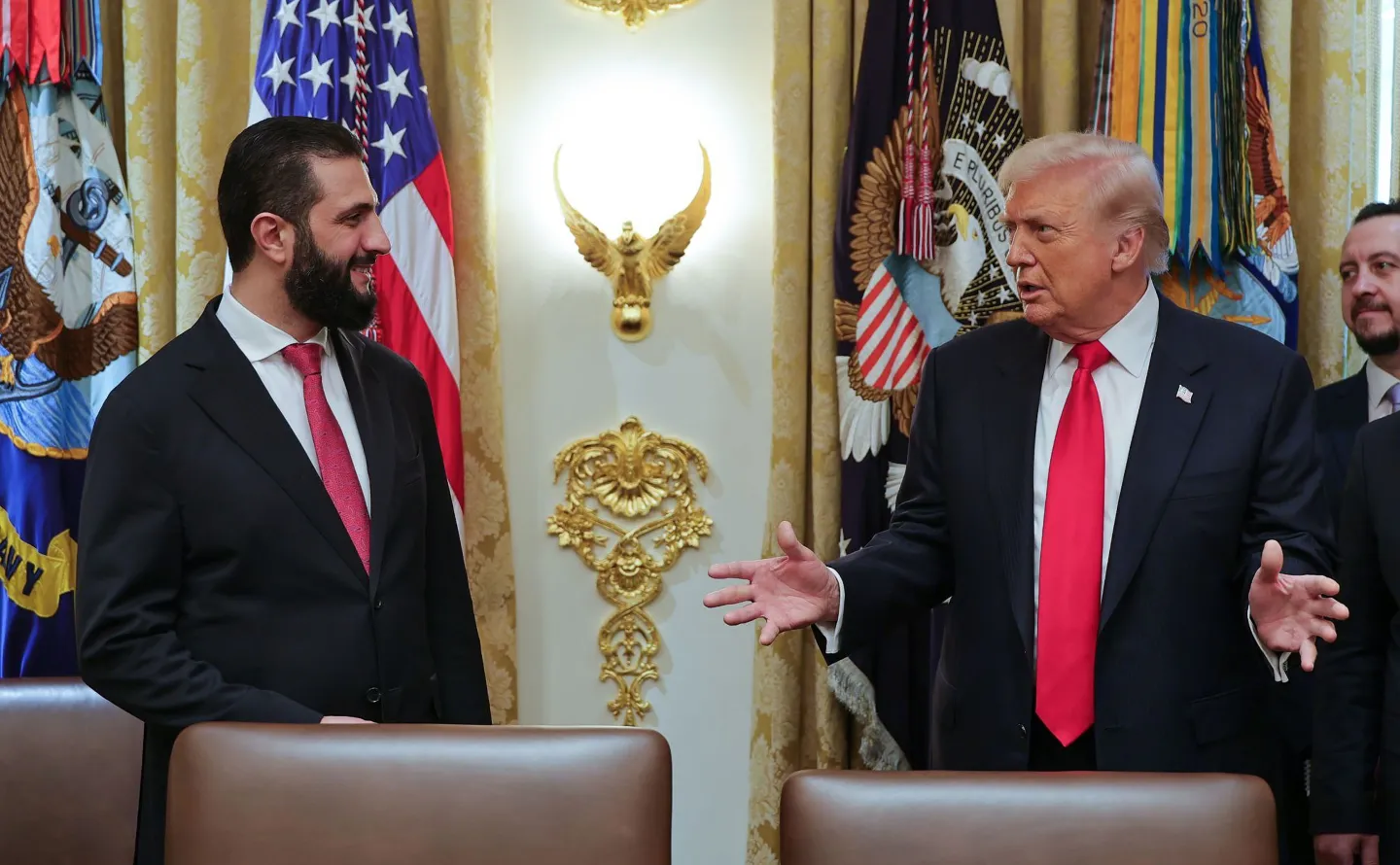 In this photo released by the Syrian Presidency press office, President Donald Trump, right, speaks with Syria's President Ahmad al-Sharaa, at the White House in Washington, Monday, Nov. 10, 2025. (Syrian Presidency press office via AP)