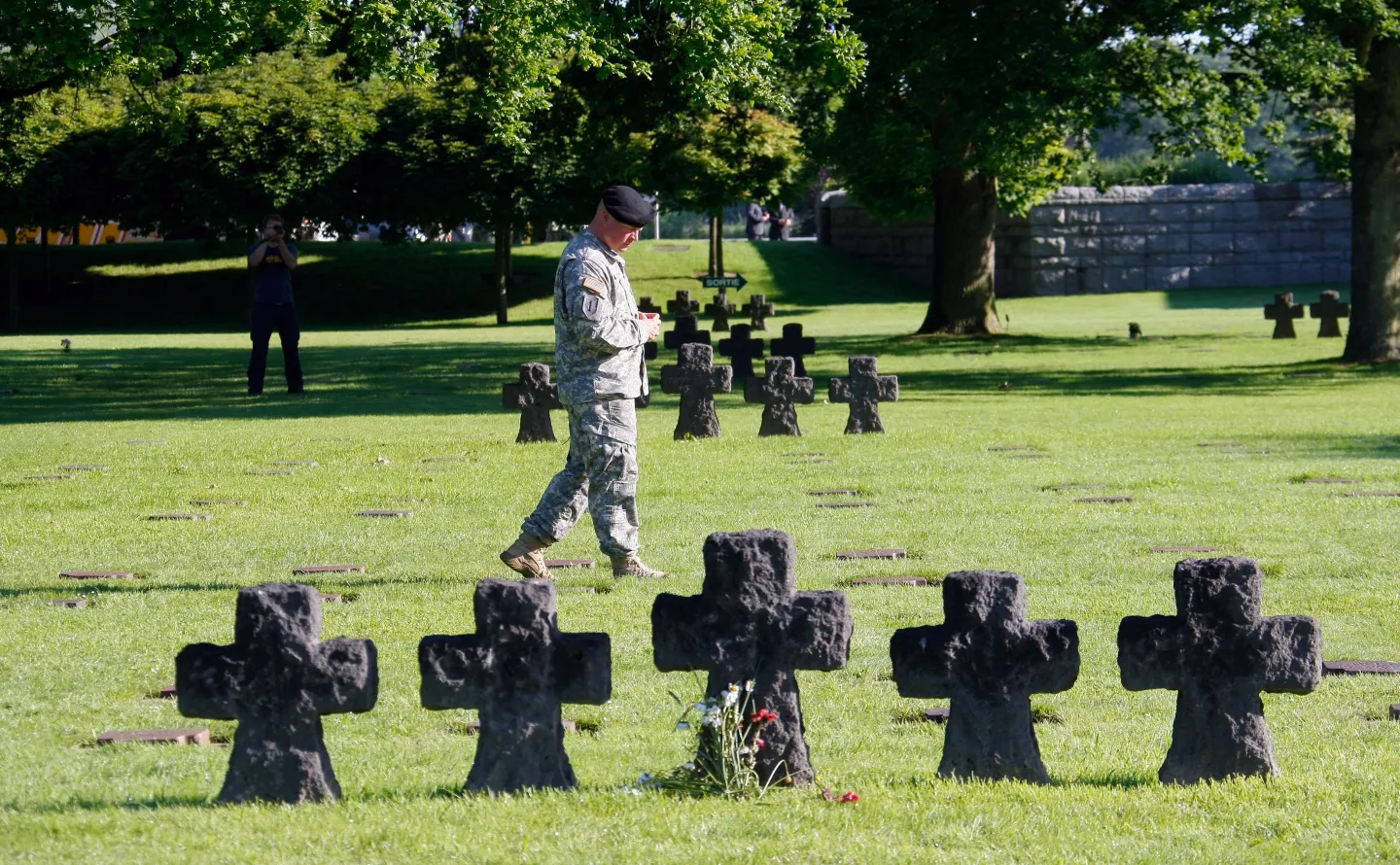 Sgt, Justin Barry of 1st Infantry Division, Fort Riley, Kansas, walks in the German cemetery at La Cambe, France, before a remembrance ceremony, Sunday, June 8, 2014, as part of D-Day commemorations. World leaders and veterans gathered by the beaches of Normandy on Friday to mark the 70th anniversary of World War Two's D-Day landings. (AP Photo/Claude Paris)