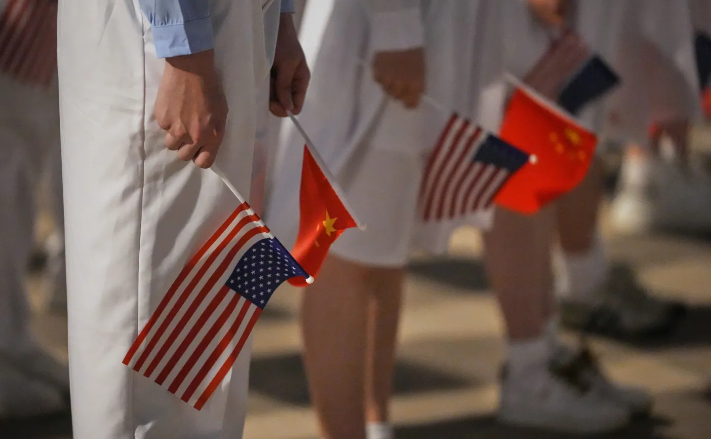 People hold American and Chinese flags for a welcome ceremony as President Donald Trump arrives on Air Force One, Wednesday, May 13, 2026, at Beijing Capital International Airport in Beijing. (AP Photo/Mark Schiefelbein)