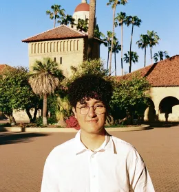 Man stands in main quad of college campus.