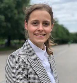 Woman in a suit faces the camera, smiling