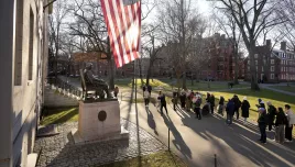 People take photographs near a John Harvard statue, left, Tuesday, Jan. 2, 2024, on the campus of Harvard University, in Cambridge, Mass.