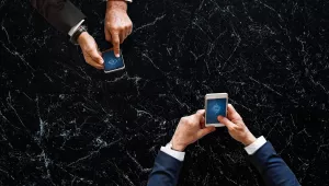 Business people syncing data by mobile phone