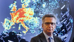 German Interior Minister Thomas de Maiziere talks to the media during his visit to the central department of fighting internet criminality (ZIT) in Giessen, Germany, Wednesday, Feb. 8, 2017. In background a map showing the amount of cyber attacks in a30 days.