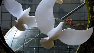 A worker cleans glass panels of the Bank of China headquarters building near a decoration setup for the Forum on China-Africa Cooperation (FOCAC) in Beijing, Sunday, Aug. 26, 2018. Chinese President Xi Jinping will chair the forum held in the capital city from Sept. 3-4, 2023.