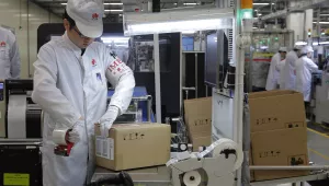 A staff member works on a mobile phone production line during a media tour of a Huawei factory in Dongguan, Guangdong, Wednesday, March 6, 2019.