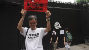 A protester holds up a placard outside the U.S. Consulate in Hong Kong, Wednesday, June 26, 2019. 