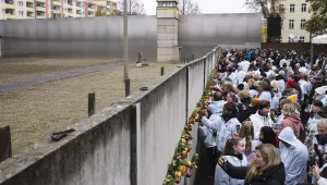 People stuck flowers in remains of the Berlin Wall during a commemoration ceremony to celebrate the 30th anniversary of the fall of the Berlin Wall at the Wall memorial site at Bernauer Strasse in Berlin, Saturday, Nov. 9, 2019.