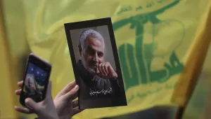 A Hezbollah supporter uses her mobile phone to takes a picture of photo of slain Iranian Revolutionary Guard Gen. Qassem Soleimani.