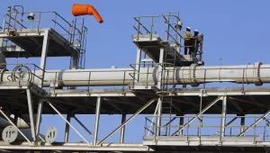 Workers stand on a platform at a Saudi Aramco oil separator processing facility in Abqaiq, near Dammam, Sept. 20, 2019.