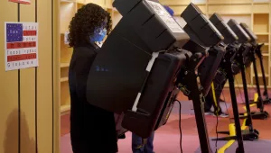 A woman casts her ballot on the first day of early voting in a recently-shuttered store at Oak Park Mall Saturday, Oct. 17, 2020, in Overland Park, Kan.