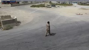 A member of the Afghan security forces walks in the sprawling Bagram air base after the American military departed, in Parwan province north of Kabul, Afghanistan, Monday, July 5, 2021.