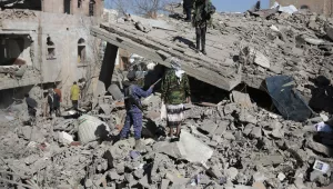 People inspect the wreckage of buildings that were damaged by Saudi-led coalition airstrikes, in Sanaa, Yemen, Tuesday, Jan. 18, 2022.