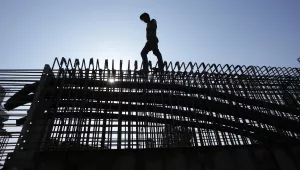 An Indian laborer works to construct a flyover in Jammu, India