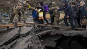 Ukrainian soldiers help a fleeing family to cross the Irpin river in the outskirts of Kyiv, Ukraine, Saturday, March 5, 2022. (AP Photo/Emilio Morenatti)