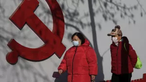 Residents wearing face masks walk by tree shadow cast on a Communist Party's logo near a residential area in Beijing, Thursday, March 2, 2023. Chinese leader Xi Jinping's agenda for the annual meeting of the ceremonial legislature: Revive the economy by encouraging consumers to spend more now that severe anti-virus controls have ended, and install a government of loyalists to intensify Communist Party control over the economy and society. (AP Photo/Andy Wong)