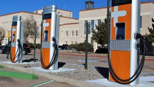 three orange electric vehicle charging stations