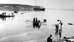 A transatlantic telephone cable is brought ashore at Clarenville, Newfoundland, for the final splice on March 8, 1957. In the background is the British naval vessel Monarch, the world’s largest cable layer, which has worked through two summers laying nearly 4,000 miles of cable to complete the two-way system between Newfoundland and Scotland.