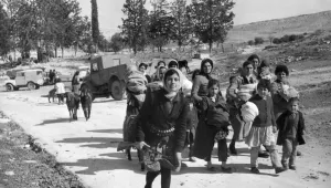Armed with a double-barrelled shotgun, a young Turkish Cypriot leads women and children from the village of Ayios Sozomenos to another nearby large Turkish village following a gun battle between Greeks and Turks on Feb. 6, 1964.