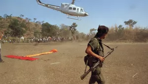 A leftist combatant of the FMLN stands guard as a U.N. helicopter lands carrying guerrilla commanders in San Jose Las Flores, Jan. 22, 1992.