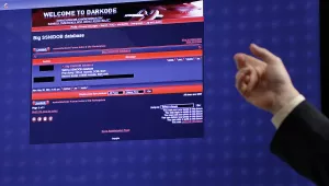 hand pointing at a screen displaying a screenshot from Darkcode