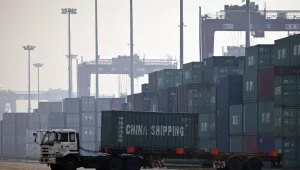 In this photo taken Feb. 28, 2012, a truck transports a container to be loaded onto a ship at a port in Tianjin, China (AP Photo/Alexander F. Yuan).