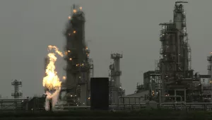 In this April 2, 2010, file photo, a Tesoro Corp. refinery, including a gas flare flame that is part of normal plant operations, is shown in Anacortes, Wash. after a fatal overnight fire and explosion. Voters in Washington state will weigh in on Initiative 732 in the 2016 election as they consider whether to approve the nation’s first direct carbon tax on the burning of fossil fuels.