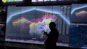A worker is silhouetted against a computer display showing a live visualization of the online phishing and fraudulent phone calls across China during the 4th China Internet Security Conference in Beijing. Aug. 16, 2016 (Ng Han Guan/Associated Press, File). Keywords: China, cyberattack