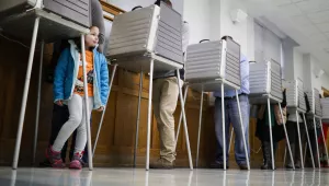 A child waits for her mother to finish voting in a polling booth at the Nativity School on Election Day, Tuesday, Nov. 8, 2016, in Cincinnati. (AP Photo/John Minchillo)