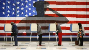 Voters line up in voting booths to cast their ballots at Robious Elementary School in Richmond, Va. on Tuesday, Nov. 8, 2016. The mural in the background was painted by 3rd and 4th graders at the school in preparation for Veterans Day.