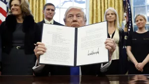 In this Saturday, Jan. 28, 2017 file photo, President Donald Trump holds up a signed Presidential Memorandum in the Oval Office in Washington. Just two days after banning travelers from seven Muslim-majority nations, U.S. President Donald Trump invited the Saudi monarch, whose kingdom includes Islam’s holiest sites, to fly to Washington. It points to the delicate balancing act Trump faces as he tries to deliver on campaign promises to exterminate “radical Islamic terrorism” without endangering political and