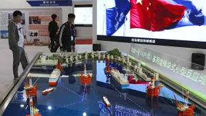 Visitors look at the models of oil tanker shaped floating nuclear reactors and oil rigs showcased at the display booth of China's state-owned China National Nuclear Corporation during the China International Exhibition on Nuclear Power Industry in Beijing. April 27, 2017 (Andy Wong/Associated Press).