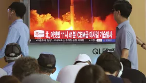 FILE - In this Saturday, July 29, 2017 photo, People watch a TV news program showing an image of North Korea's latest test launch of an intercontinental ballistic missile (ICBM), at the Seoul Railway Station in Seoul, South Korea. South Korea's latest leader Moon Jae-in told U.S. President Donald Trump he's happy to talk about North Korea's ICBM test but after his vacation. It might seem like an oddly timed break for a relatively new president during his country's biggest crisis. The signs read "North Korea