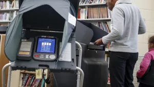 A voter casts his ballot into an electronic voting machine at a polling station located in the Taft Information Technology High School in Cincinnati. November 7, 2017 (John Minchillo/Associated Press). Keywords: electronic voting machine, Cincinnati